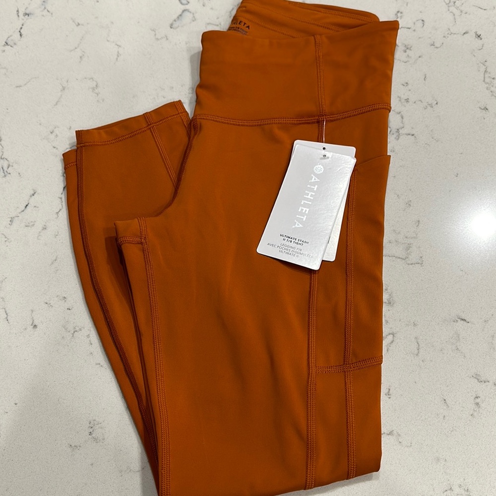 Athleta ultimate stash 7/8 tight.  Never worn with tags side deep pockets.